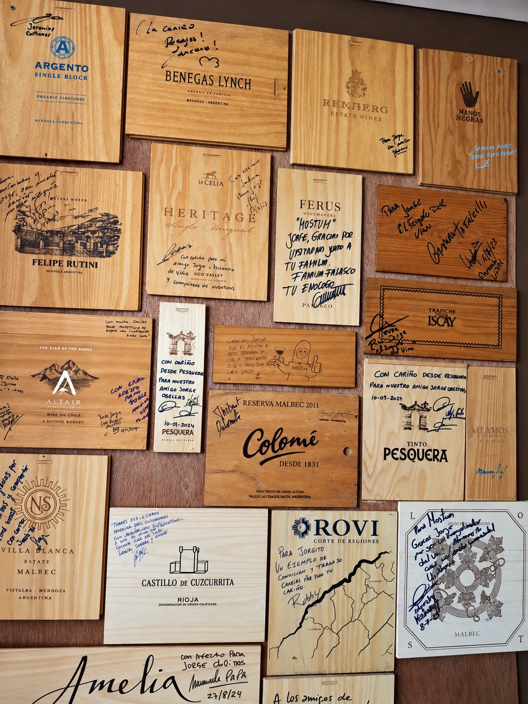 Pared de tapas de cajas dedicadas y firmadas por enólogos y propietarios de bodegas